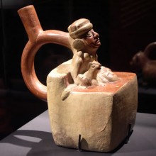 Botella asa-estribo: Gobernante-ancestro sentado acompañado de felino ataviado con túnica,capa, tocado y collar. Museo Larco, Lima - Perú / ML000641