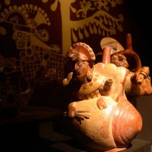 Botella asa-estribo: "Cara Arrugada " con tocado de felino y cuerpo de concha Strombus , portando estólica y dardos. Museo Larco, Lima - Perú